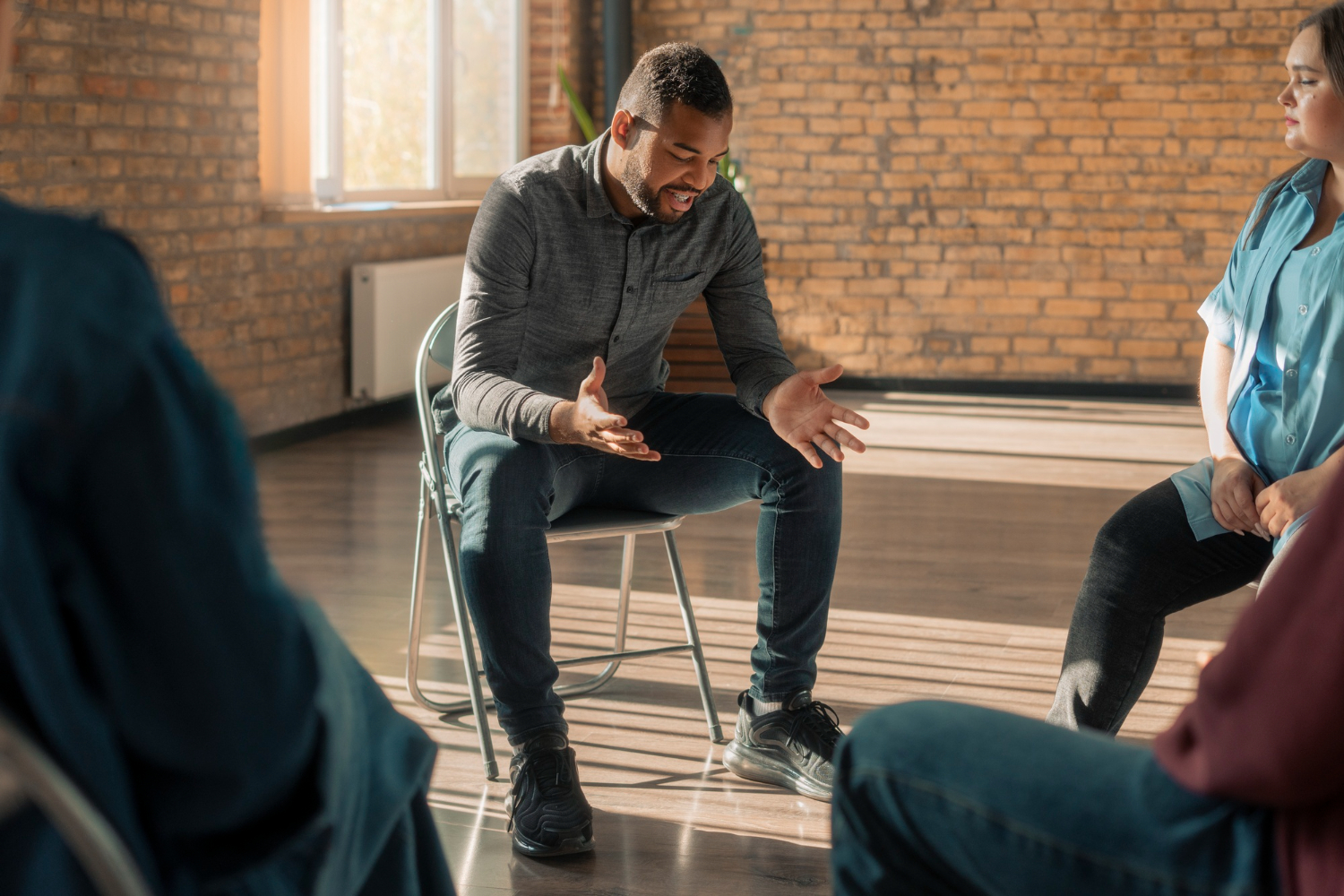 individual speaking in group therapy while discussing relapse and treatment options during addiction recovery
